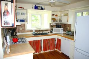 a kitchen with white cabinets and a white refrigerator at Above Sleepy Hollow - A Hidden Getaway in Hedgesville
