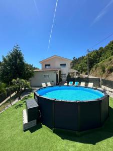 a pool in a yard with chairs and a house at Vila Teixeira in Amarante