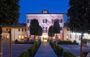 un grande edificio bianco con alberi di fronte di Al Tezzon Hotel a Camposampiero