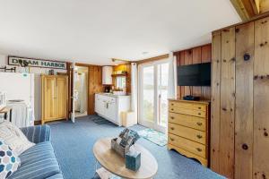 Dream Harbor Cottage في Surry: غرفة معيشة مع أريكة زرقاء ومطبخ