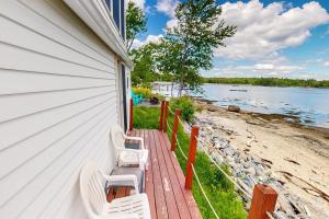 a row of white chairs sitting on the side of a house at Dream Harbor Cottage in Surry