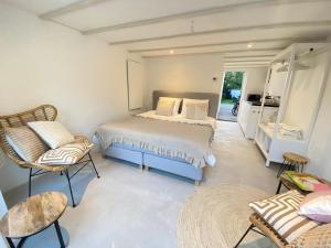 a bedroom with a bed and chairs in a room at Tranquil Guest House in Zandvoort