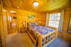 a bedroom with a bed in a log cabin at Newton Creek Cabin in Hill City