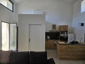 a living room with a couch and a kitchen at La Bergerie in Narbonne