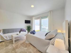 ein weißes Schlafzimmer mit einem Bett und einem Fenster in der Unterkunft Atico Cartagena centro historico Parking in Cartagena