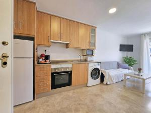 eine Küche mit Holzschränken und einer Waschmaschine in der Unterkunft Atico Cartagena centro historico Parking in Cartagena