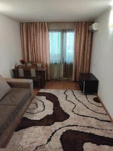 a living room with a couch and a rug at Двухкомнатная квартира in Uralsk