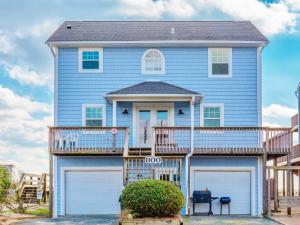 a blue house with a balcony and two garage doors at A Grande Green in Surf City
