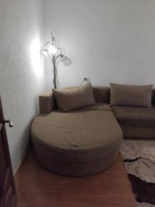 a living room with a ottoman and a couch at Двухкомнатная квартира in Uralsk
