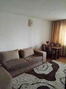 a living room with a couch and a table at Двухкомнатная квартира in Uralsk