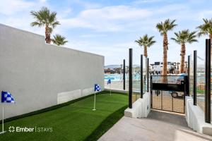 a golf course with palm trees in the background at Baseball Beach House at Desert Color (by Ember Stays) in St. George