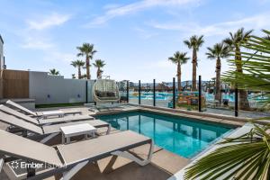 a swimming pool with a swing and palm trees at Baseball Beach House at Desert Color (by Ember Stays) in St. George