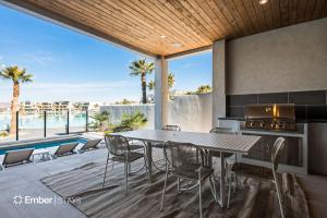 a patio with a table and chairs and a pool at Baseball Beach House at Desert Color (by Ember Stays) in St. George