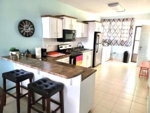 a kitchen with a counter with stools in it at 2-bedroom Condo in Boqueron in Cabo Rojo