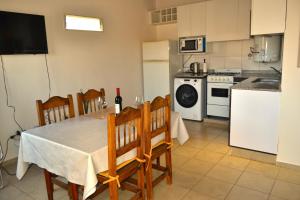 a kitchen with a table and chairs and a kitchen with a refrigerator at MendoApart completo con cochera in La Cieneguita +3 photos