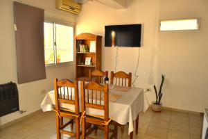 a dining room with a table with chairs and a refrigerator at MendoApart completo con cochera in La Cieneguita