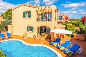 uma villa com piscina em frente a uma casa em Villa Marcolis Playa em Cala Galdana