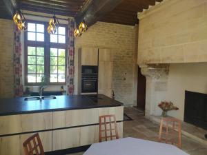 a kitchen with a sink and a stove top oven at Gîtes La Grande Ferme Crépon - à la campagne 5mn d'Arromanches et 10mn de Bayeux in Crépon
