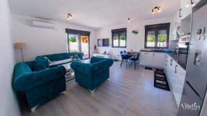 a living room with two blue couches and a kitchen at Villa Elysian Blagaj in Blagaj