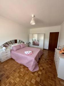 1 dormitorio con 1 cama con sábanas rosas y espejo en Vila Teixeira, en Amarante
