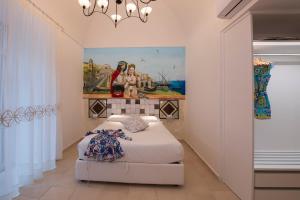 アマルフィにあるHotel Antica Repubblica in Amalfi center at 100mt from the sea with payment parkingのベッドルーム1室(ベッド1台付)が備わります。壁には絵画が飾られています。