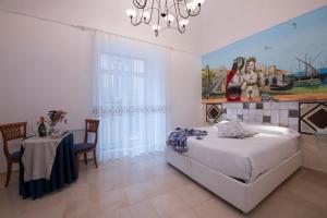 a bedroom with a bed and a table and a chandelier at Hotel Antica Repubblica in Amalfi center at 100mt from the sea with payment parking in Amalfi