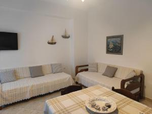 a living room with two beds and a table at Nianiari house in Kimolos