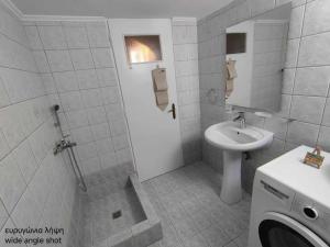 a white bathroom with a sink and a toilet at Nianiari house in Kimolos +9 photos
