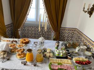 a table with breakfast foods and drinks on it at Pátio da Villa - Coruche Boutique Guest House in Coruche