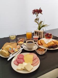 a table with plates of breakfast foods and drinks at Hotel Alborada in Concepción