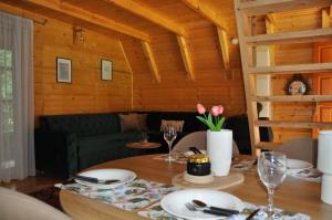 a dining room with a table and a couch at Nadiaa Wood House in Ilidža