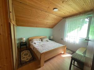 a bedroom with a bed in a room with a window at Jezero apartment in Palić