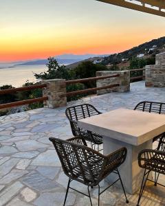 a table and chairs on a patio with the sunset at Captain's Pounda Suite in Apróvaton