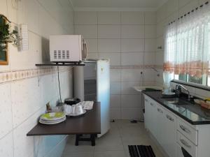 una pequeña cocina con nevera y microondas en Flats Santa Genoveva, en Goiânia