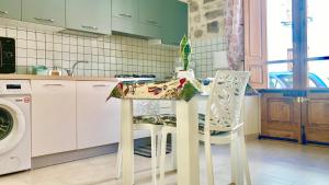 cocina con mesa y 2 sillas en Casa Nina - 10' dalla spiaggia en Gonnesa