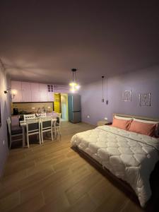 a bedroom with a large bed and a dining room at Mirelas guesthouse in Pogradec