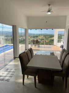 a dining room with a table and chairs with a view at Casa Capitólio com Vista para Escarpas do Lago in Capitólio