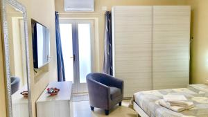 1 dormitorio con cama, silla y espejo en Casa Nina - 10' dalla spiaggia en Gonnesa