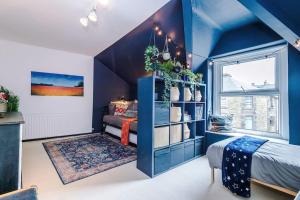 ein blaues Zimmer mit einem Bett und einem Regal mit Pflanzen in der Unterkunft Rufloreo Dale - homely and central in Buxton
