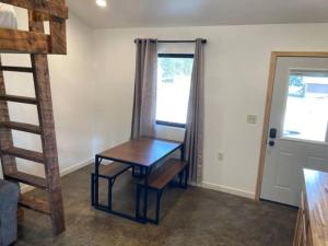 a room with a wooden table and a ladder at Gold Valley Camp Cabin 4 in Custer +1 photo
