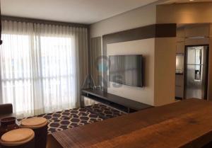 a living room with a television and a kitchen at ANSNEGOCIOS APTO CHARMOSO PRAIA MARISCAL 101 Italy in Canto Grande