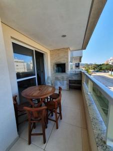 a table and chairs on the balcony of a house at ANSNEGOCIOS APTO CHARMOSO PRAIA MARISCAL 101 Italy in Canto Grande