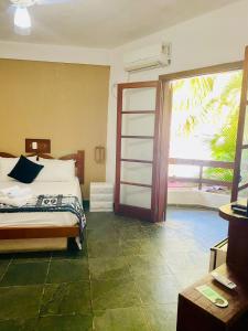 a bedroom with a bed and a sliding glass door at Maresias Praia Hotel in Maresias