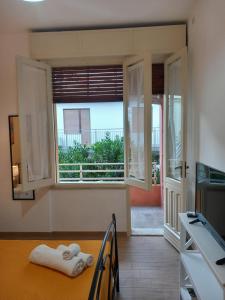 Habitación con ventana y mesa con toallas. en Divina Cuspide en Guspini