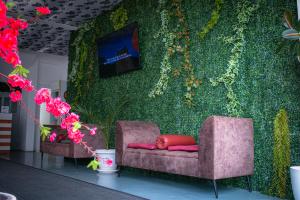 a room with two chairs and a green wall with flowers at Hotel Fron in Sarandë