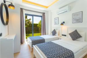 a bedroom with two beds and a balcony at Lobelya Suites in Kas +65 photos