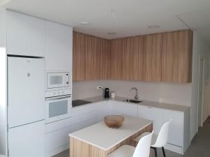 a kitchen with white cabinets and a table with chairs at Casamarcati in Calasparra
