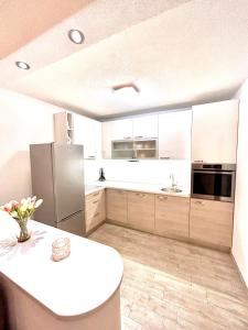 a kitchen with white cabinets and a white counter top at Apartman Zorka in Povlja