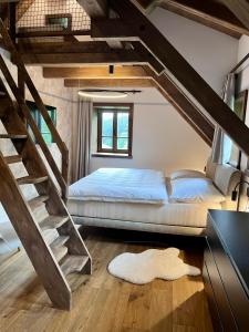 a bedroom with a bed and a staircase at Roubenka Pod hvězdami in Strážné