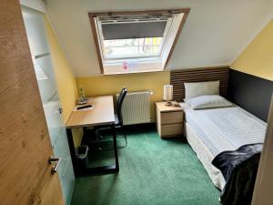 a small bedroom with a bed and a desk at Hotel Residenz Stockstadt in Stockstadt am Main